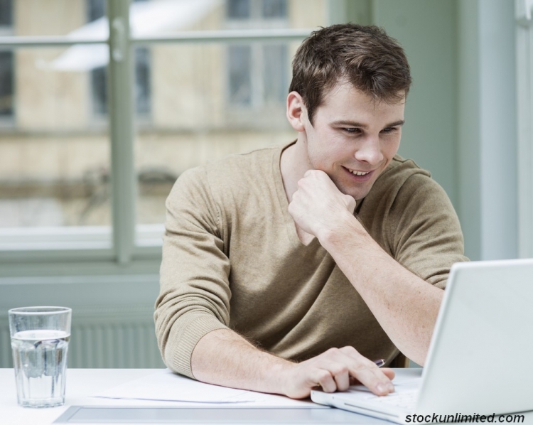 Jeune homme travaillant devant son ordinateur